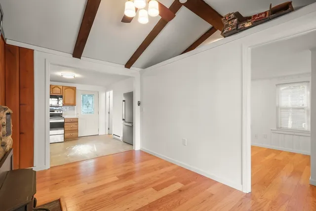 a view of a hallway with wooden floor and a living room
