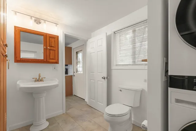a bathroom with a toilet sink and mirror