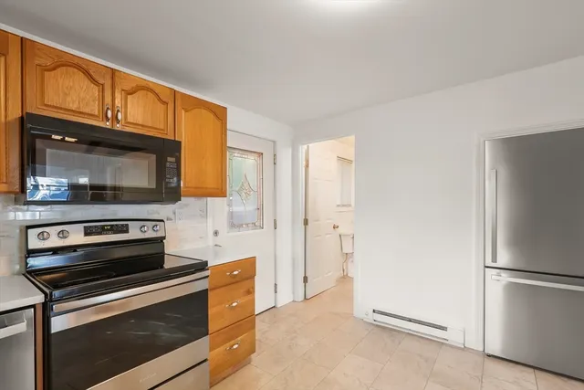 a kitchen with granite countertop a refrigerator stove and microwave