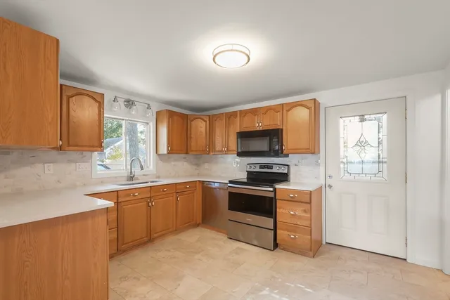 a kitchen with stainless steel appliances granite countertop a stove sink and microwave
