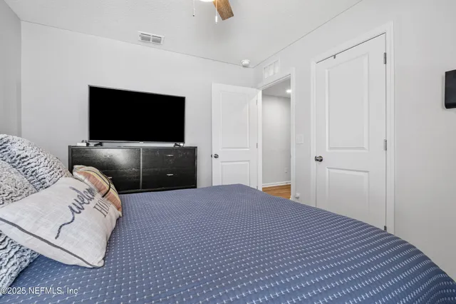 a bedroom with a bed and a flat screen tv
