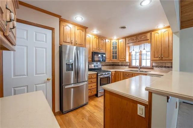 a kitchen with stainless steel appliances granite countertop a refrigerator and a stove top oven