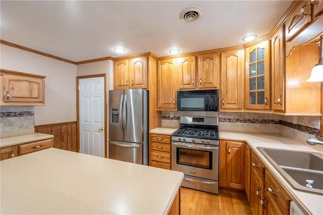 a kitchen with granite countertop a stove sink and refrigerator