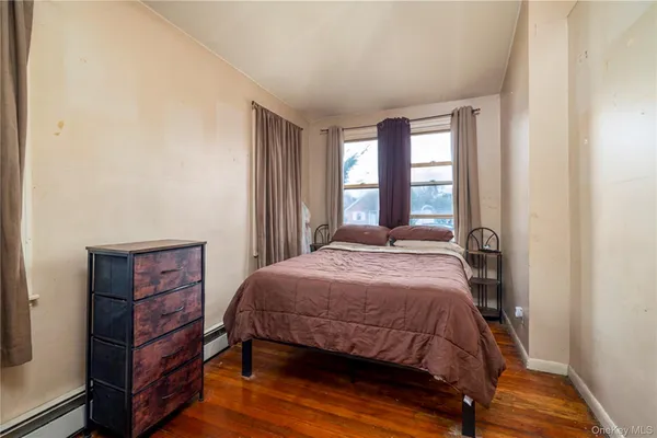 a bedroom with a bed a dresser and a window