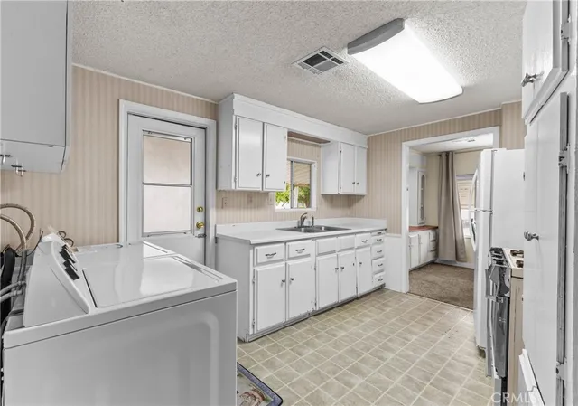 a kitchen with white cabinets and white appliances