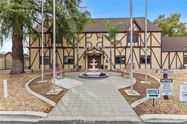 a view of a patio with table and chairs under an umbrella with a barbeque