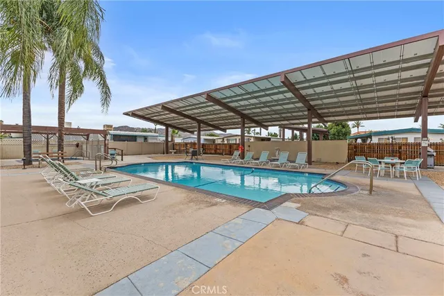 a view of a swimming pool with a chair and tables in the patio