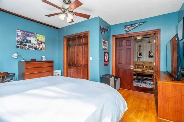 a bedroom with a bed and a flat tv screen on dresser