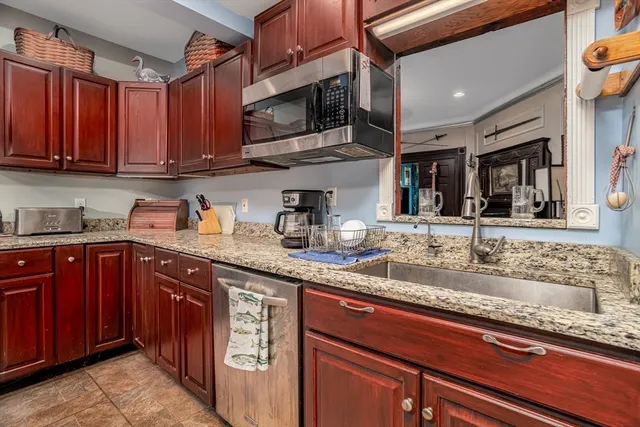 a kitchen with stainless steel appliances granite countertop a sink stove and microwave