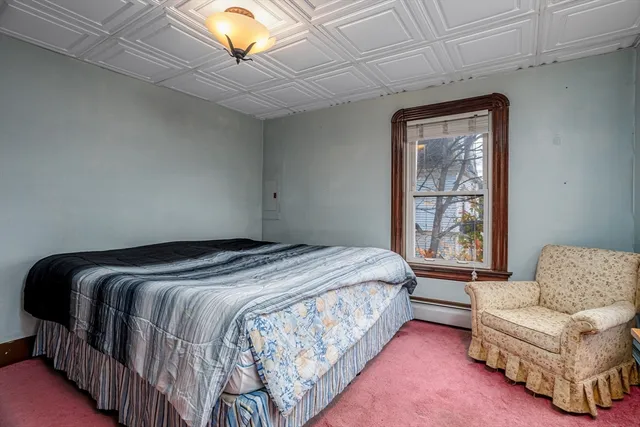 a bedroom with a bed couch and window