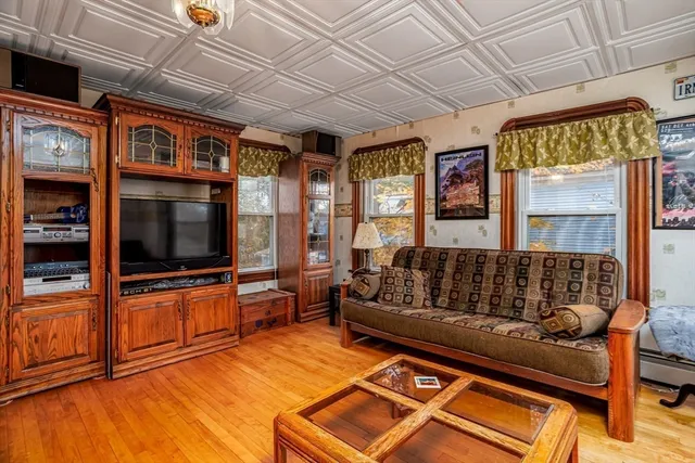 a living room with furniture a flat screen tv and a floor to ceiling window