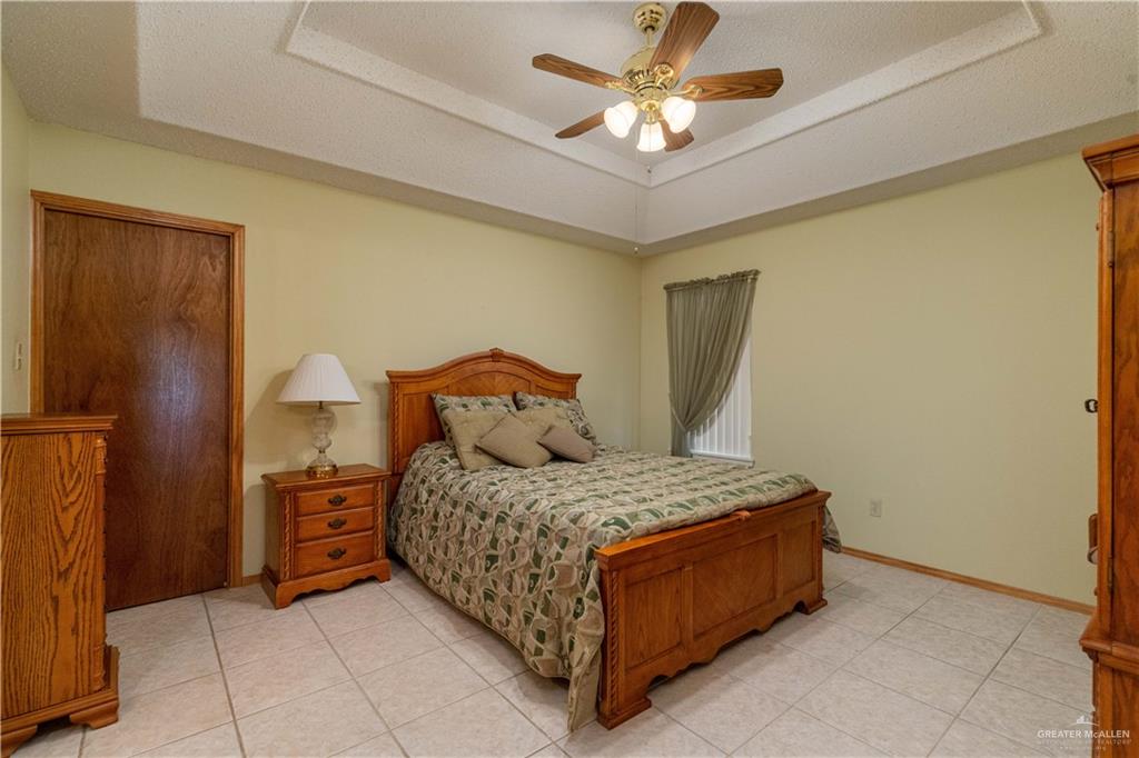 1717 Sun Street Mission, TX 78572 - Photo 11 of 19 a bedroom with a bed and a chandelier