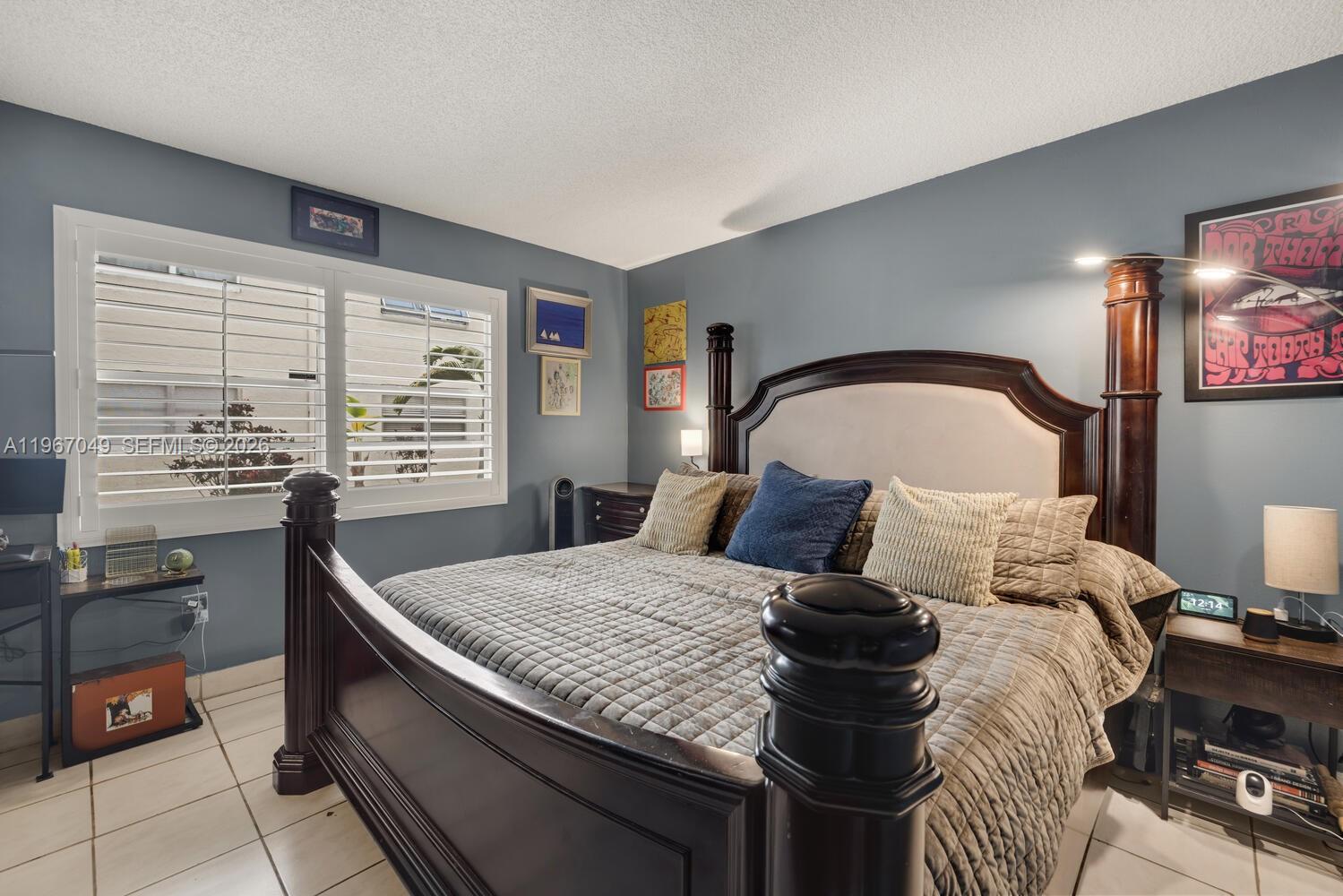 7785 Southwest 86th Street, Unit E119 Miami, FL 33143 - Photo 12 of 33 a large bed sitting in a bedroom next to a window