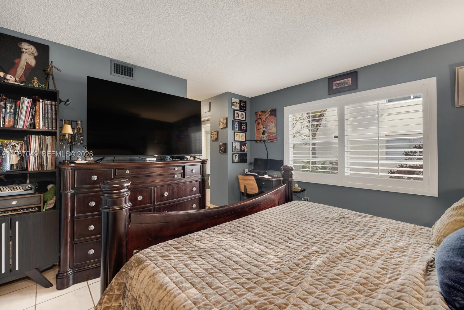 7785 Southwest 86th Street, Unit E119 Miami, FL 33143 - Photo 13 of 33 a bedroom with a bed and a flat screen tv