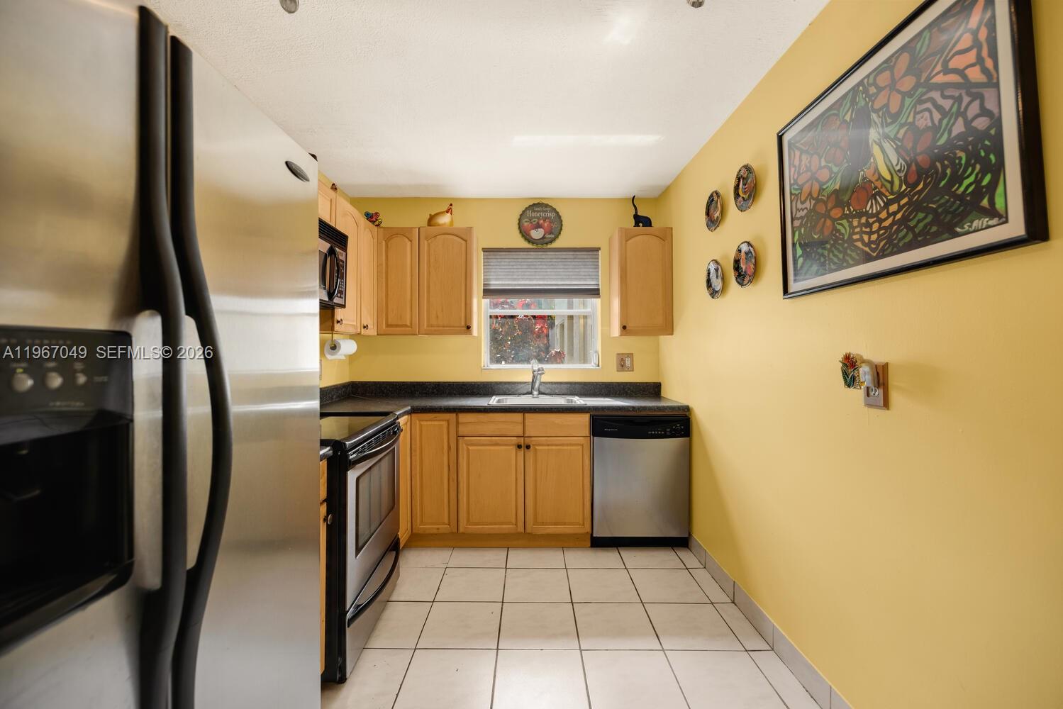 7785 Southwest 86th Street, Unit E119 Miami, FL 33143 - Photo 16 of 33 a kitchen with a refrigerator and a sink