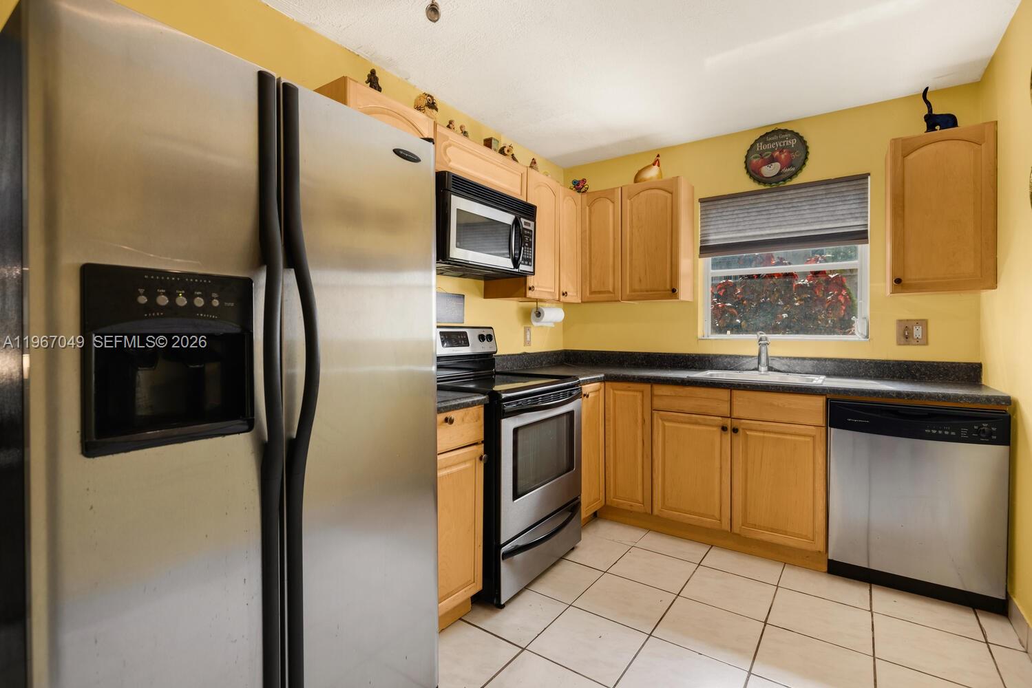 7785 Southwest 86th Street, Unit E119 Miami, FL 33143 - Photo 17 of 33 a kitchen with stainless steel appliances granite countertop a refrigerator and a sink