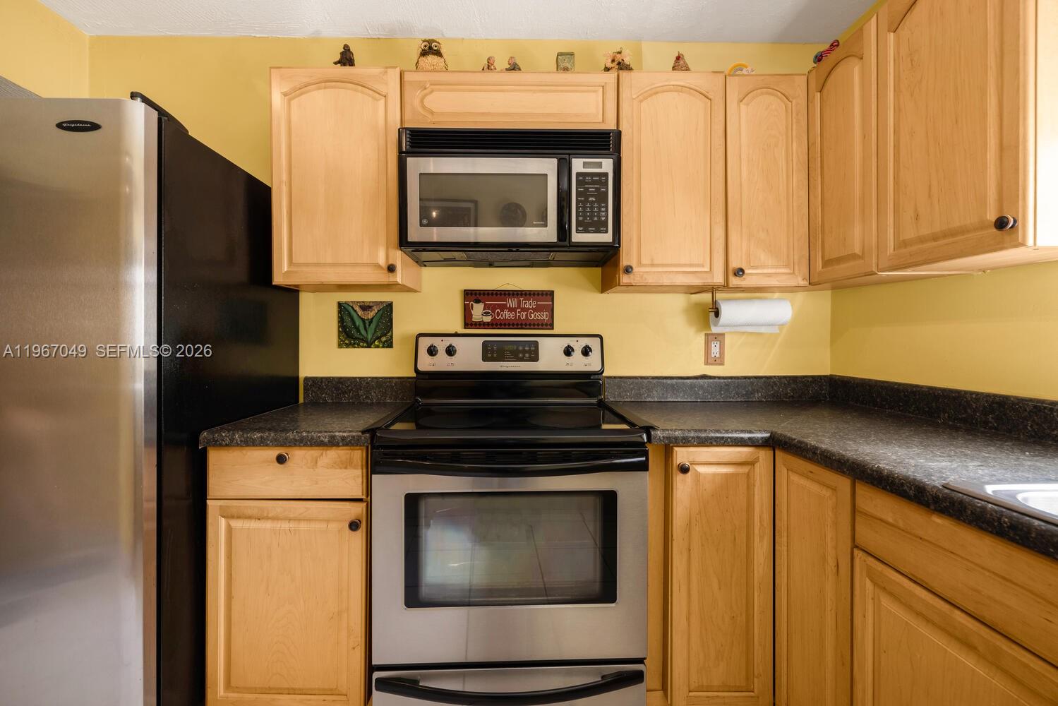 7785 Southwest 86th Street, Unit E119 Miami, FL 33143 - Photo 18 of 33 a kitchen with stainless steel appliances granite countertop a stove microwave and refrigerator