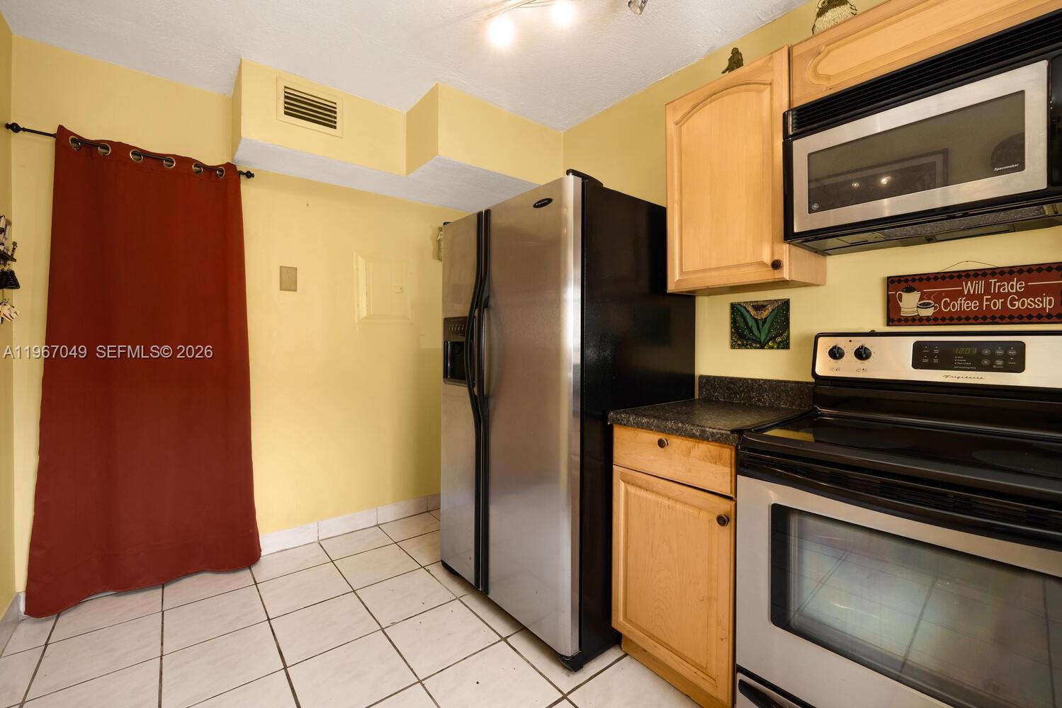 7785 Southwest 86th Street, Unit E119 Miami, FL 33143 - Photo 19 of 33 a kitchen with stainless steel appliances granite countertop a refrigerator and a stove top oven