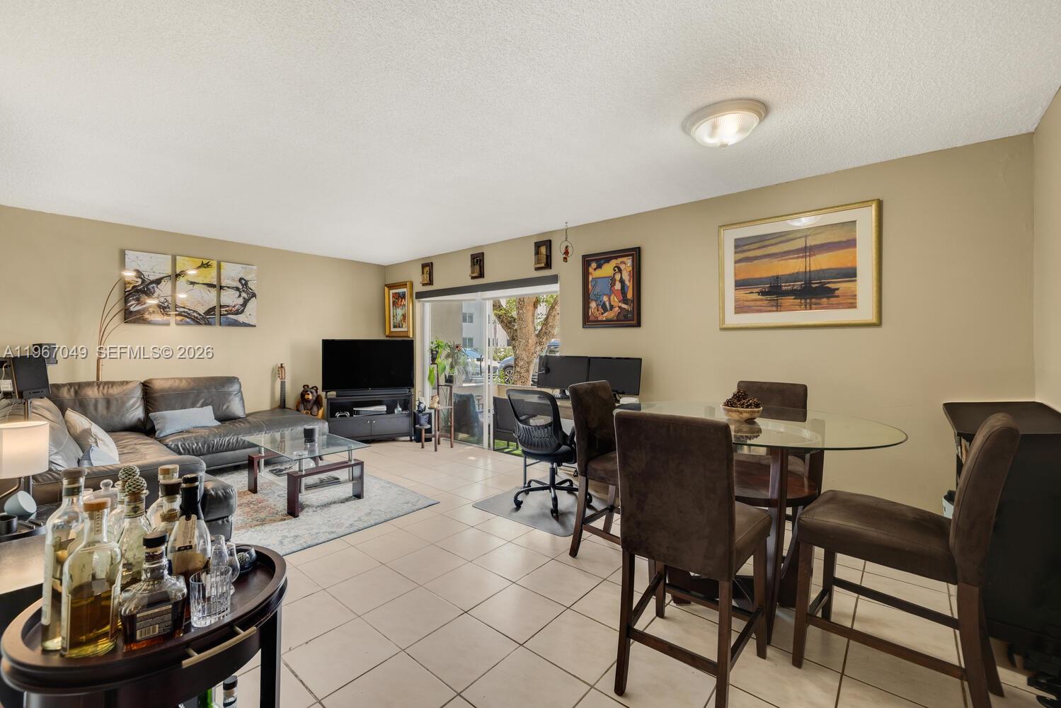 7785 Southwest 86th Street, Unit E119 Miami, FL 33143 - Photo 3 of 33 a living room with furniture a flat screen tv and a fireplace