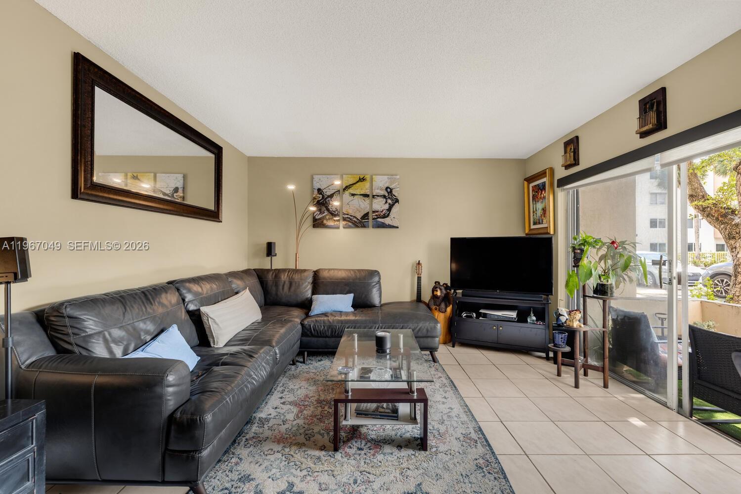 7785 Southwest 86th Street, Unit E119 Miami, FL 33143 - Photo 5 of 33 a living room with furniture and a flat screen tv