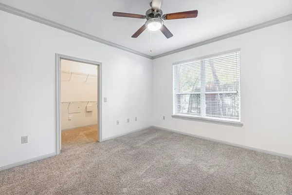 an empty room with windows and fan