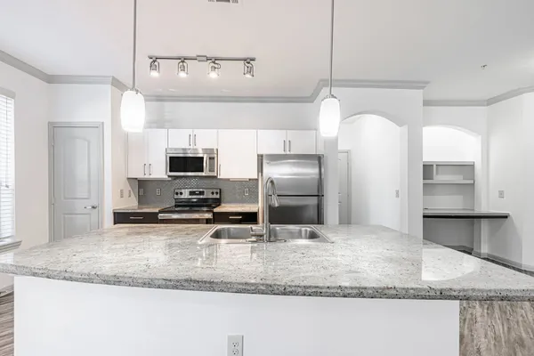 a kitchen with stainless steel appliances granite countertop a sink refrigerator and microwave