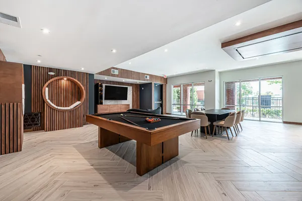 a kitchen with stainless steel appliances granite countertop a stove top oven a sink dishwasher a dining table and chairs with wooden floor