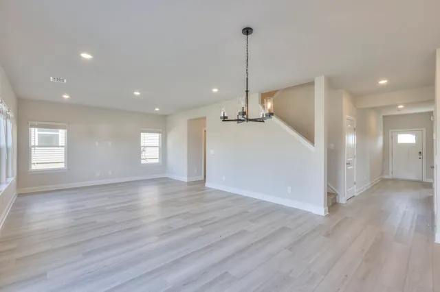 a view of empty room with wooden floor and window