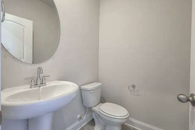 a bathroom with a sink toilet and mirror