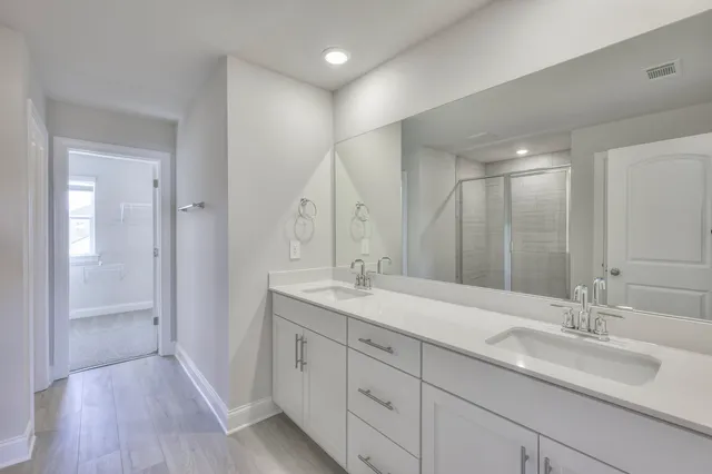 a bathroom with a double vanity sink mirror and shower