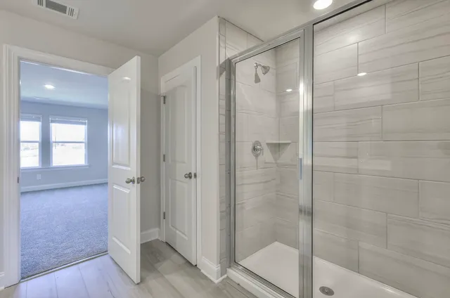 a bathroom with a shower and a glass door