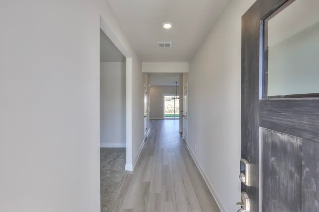 a view of a hallway with wooden floor