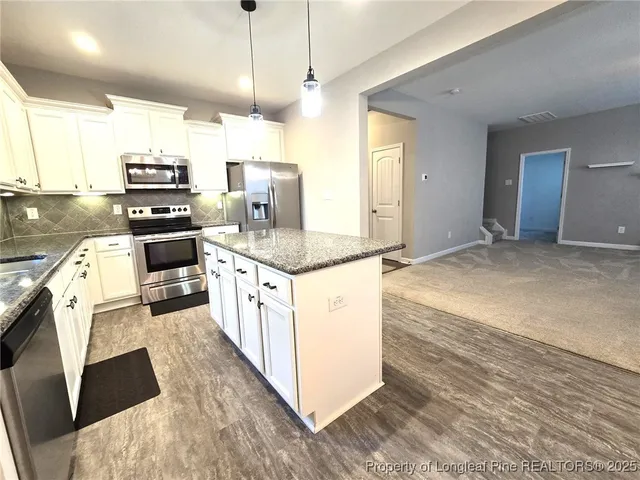 a kitchen with granite countertop a stove and a sink