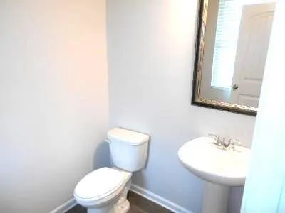 a white toilet sitting next to a bathroom sink