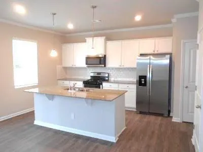 a kitchen with stainless steel appliances granite countertop a sink a refrigerator and a stove