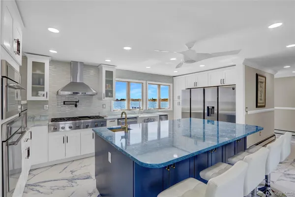 a kitchen with stainless steel appliances granite countertop a kitchen island a stove a sink a dining table and chairs