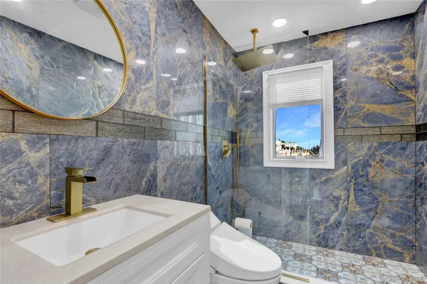 a bathroom with a sink a toilet and shower