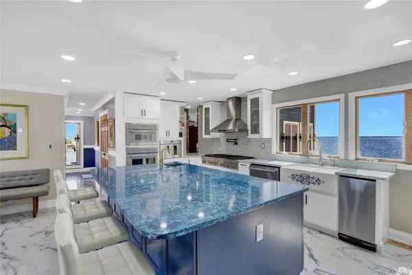 a large kitchen with stainless steel appliances granite countertop a large counter top and a stove