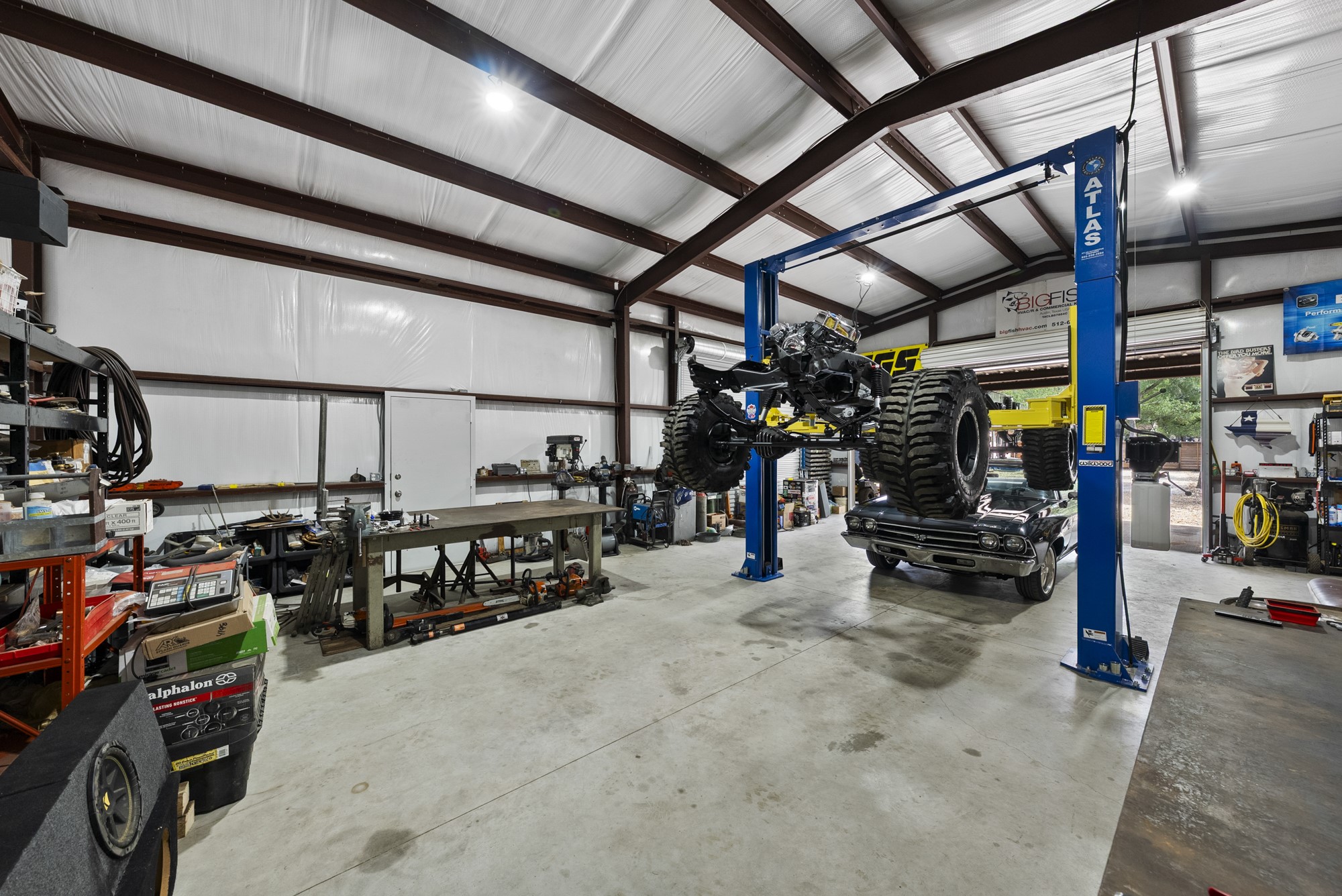 2802 Robin Road Manchaca, TX 78652 - Photo 26 of 40 Expansive metal-framed workshop featuring a concrete floor, high ceilings, and a professional-grade vehicle lift