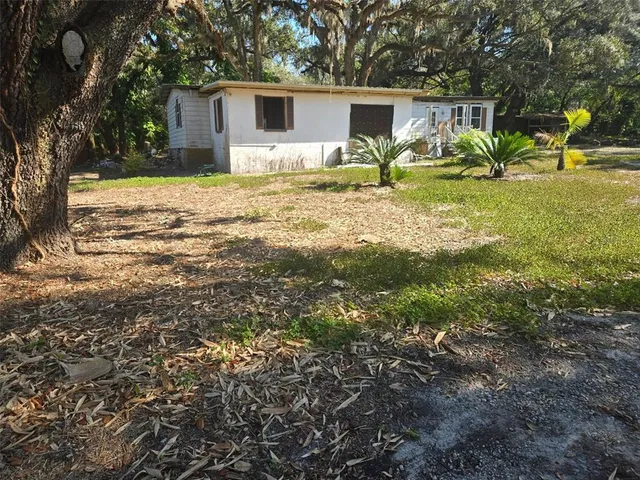 a backyard of a house with table and chairs