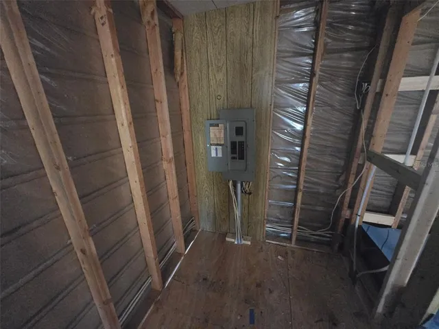a view of an empty room with wooden floor and stairs