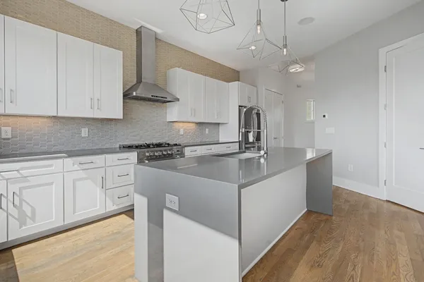 a kitchen with stainless steel appliances granite countertop a sink a stove and a refrigerator