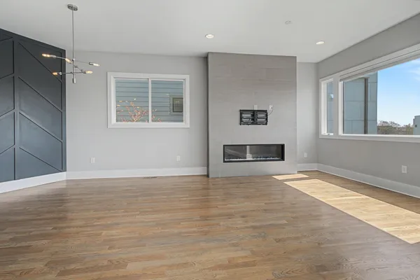 a view of an empty room with a window and fire place