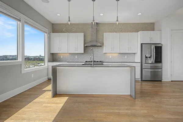 a kitchen with kitchen island a counter top space a sink stainless steel appliances and cabinets