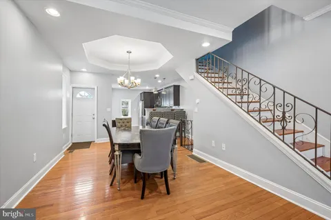 a view of a dining room with furniture a chandelier and wooden floor
