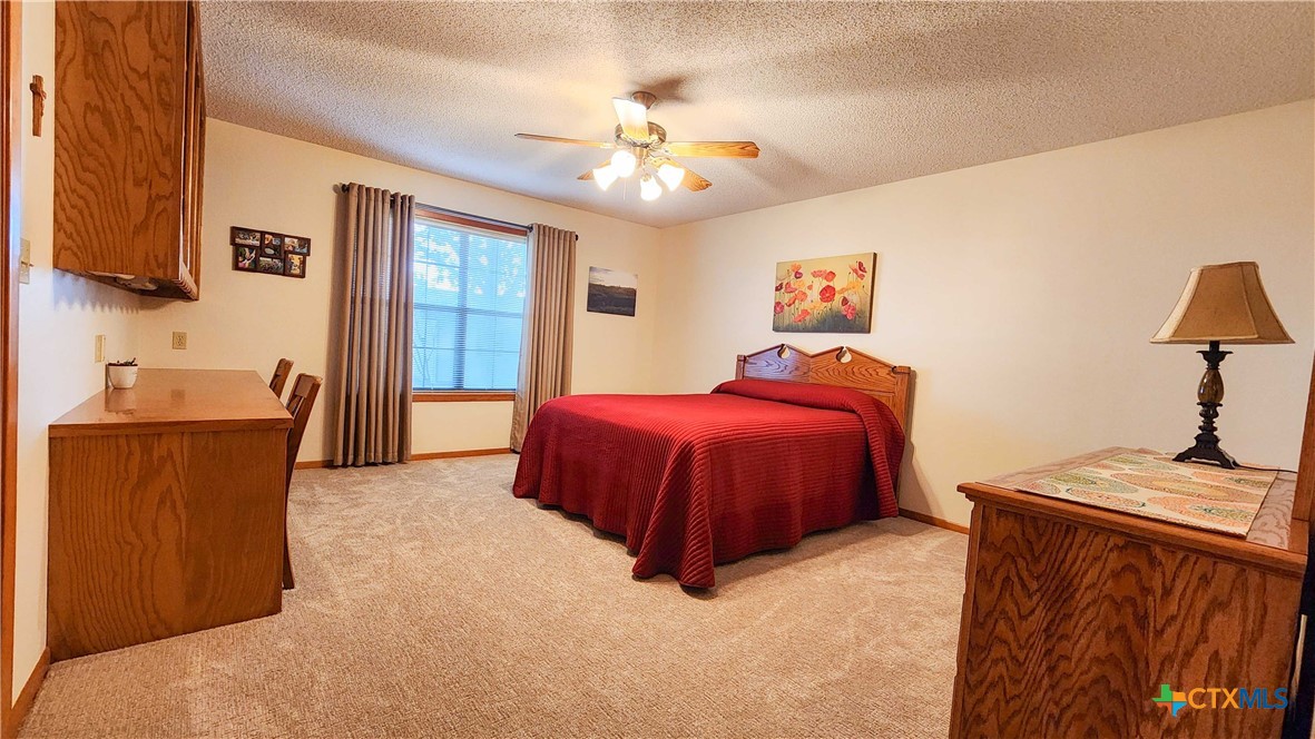 847 Oliver Road Victoria, TX 77904 - Photo 26 of 47 a spacious bedroom with a bed and a chandelier