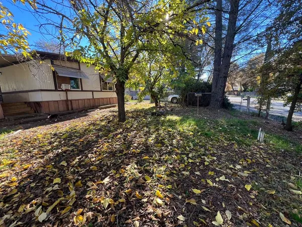 a view of a small house with backyard and furniture