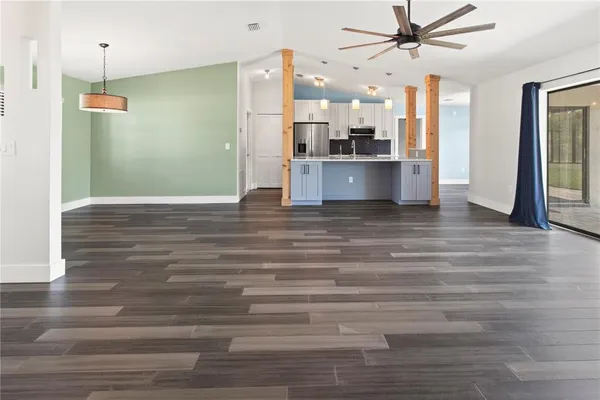 a view of a kitchen with a refrigerator a ceiling fan and wooden floor