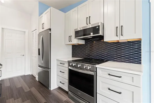 a kitchen with stainless steel appliances a stove microwave and refrigerator