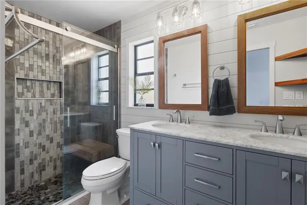 a bathroom with a granite countertop sink toilet and shower